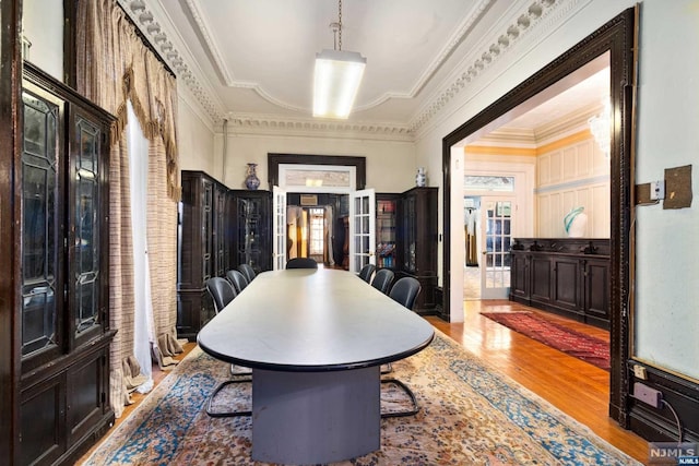 foyer with wood-type flooring, plenty of natural light, french doors, and crown molding