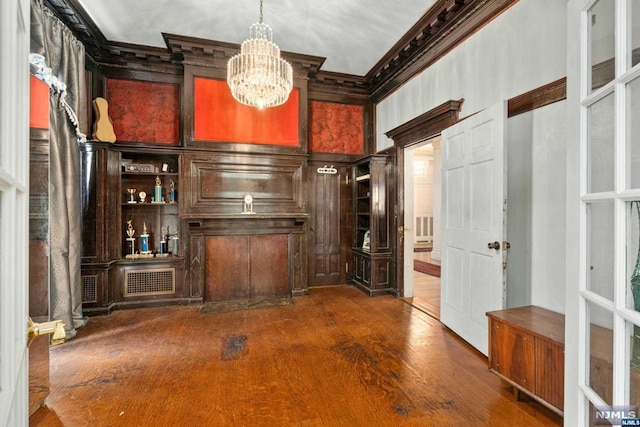 unfurnished office with crown molding, dark hardwood / wood-style floors, and an inviting chandelier