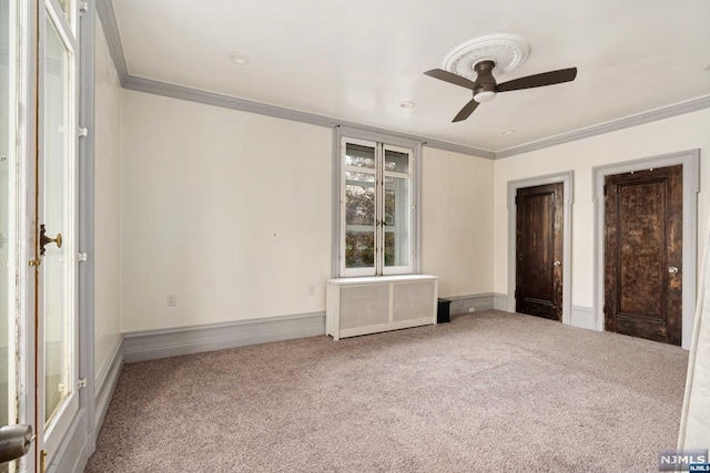 unfurnished bedroom with carpet flooring, radiator, ceiling fan, and crown molding