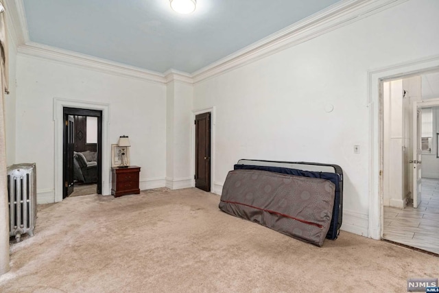 carpeted bedroom with ornamental molding and radiator