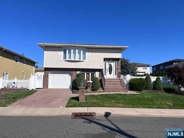 view of front of house featuring a front lawn and a garage