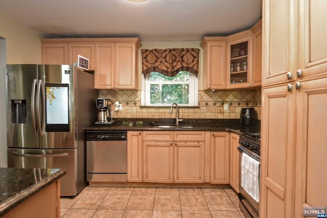 kitchen featuring dark stone countertops, sink, appliances with stainless steel finishes, and tasteful backsplash