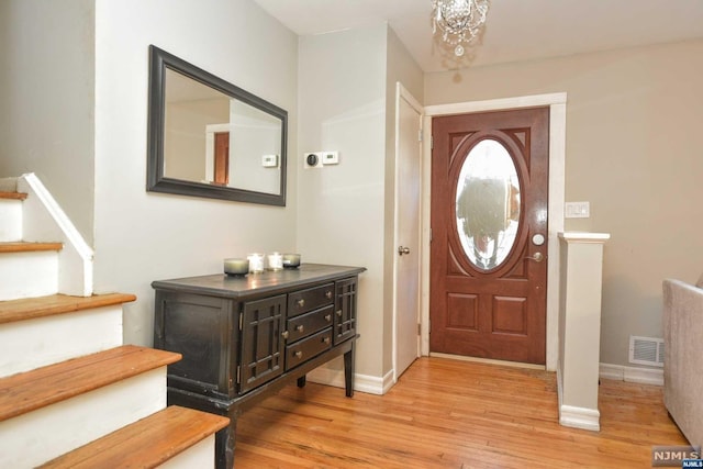 entryway featuring a chandelier and light hardwood / wood-style floors