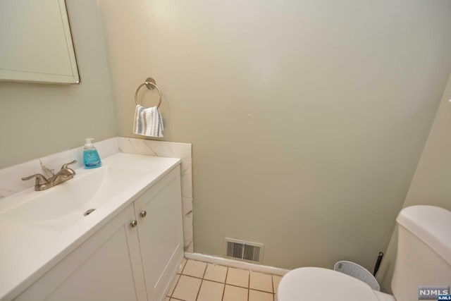 bathroom with tile patterned flooring, vanity, and toilet