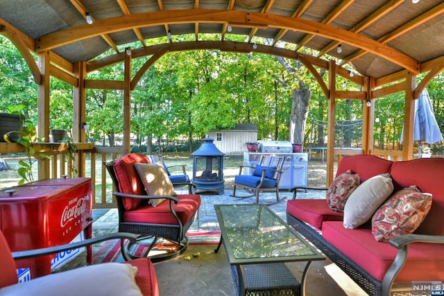 view of patio / terrace with a shed, an outdoor living space with a fire pit, and a grill