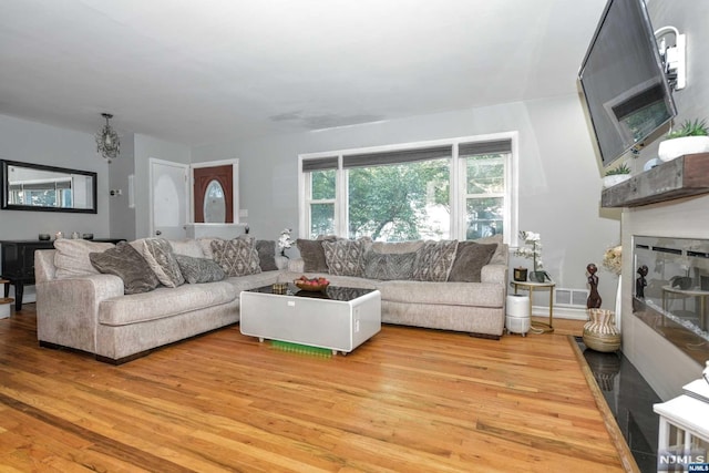 living room with a notable chandelier and light wood-type flooring