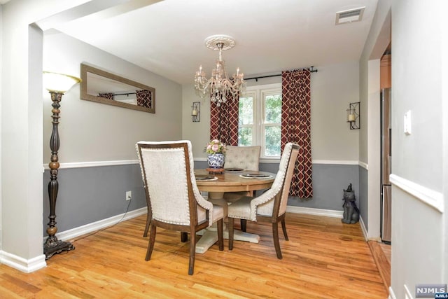 dining space featuring a notable chandelier and light hardwood / wood-style floors