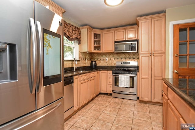 kitchen featuring tasteful backsplash, stainless steel appliances, sink, light brown cabinets, and light tile patterned flooring