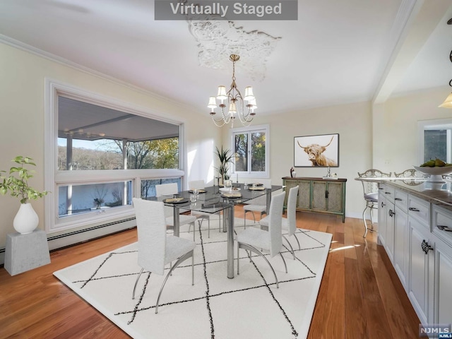 dining area with an inviting chandelier, light hardwood / wood-style flooring, and crown molding