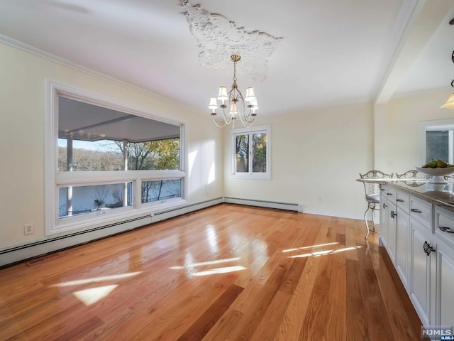 unfurnished dining area with beam ceiling, light hardwood / wood-style flooring, a baseboard heating unit, a notable chandelier, and crown molding