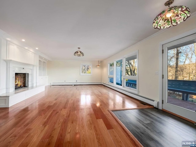 unfurnished living room featuring a tile fireplace, a baseboard radiator, light hardwood / wood-style flooring, and a wealth of natural light