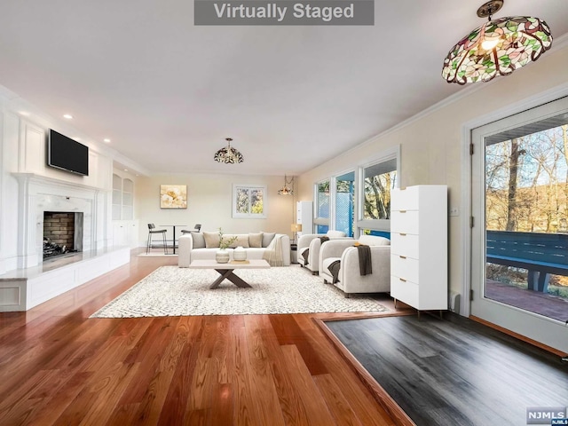 unfurnished living room featuring crown molding, wood-type flooring, a fireplace, and a wealth of natural light