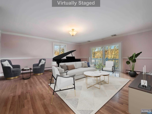 living room featuring hardwood / wood-style floors, a baseboard radiator, and crown molding