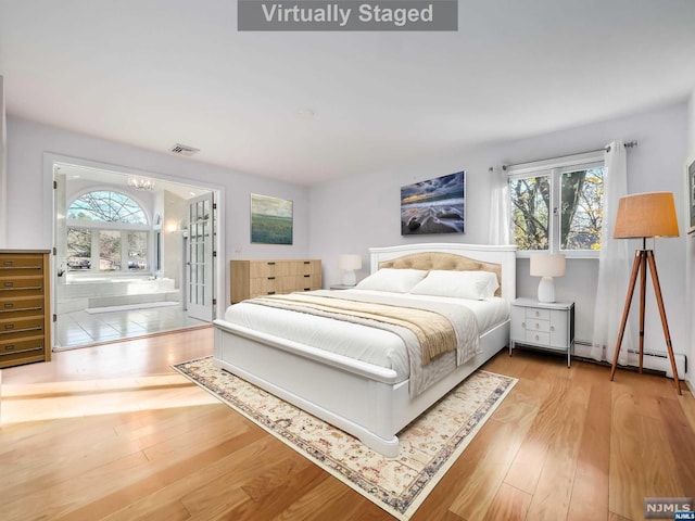 bedroom with multiple windows, wood-type flooring, and an inviting chandelier