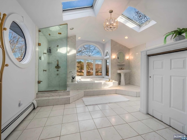 bathroom featuring tile patterned flooring, shower with separate bathtub, a skylight, and baseboard heating