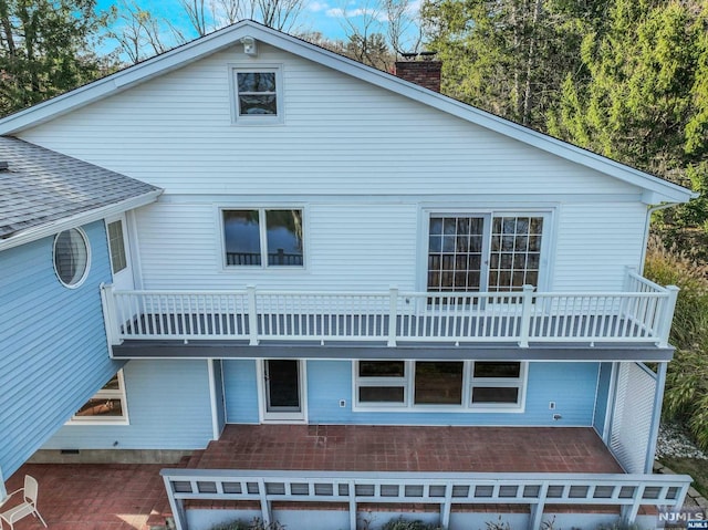 rear view of property featuring a patio area and a balcony