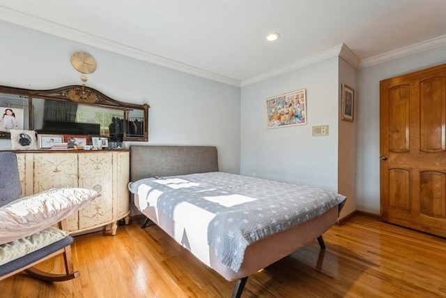 bedroom with light hardwood / wood-style floors and crown molding