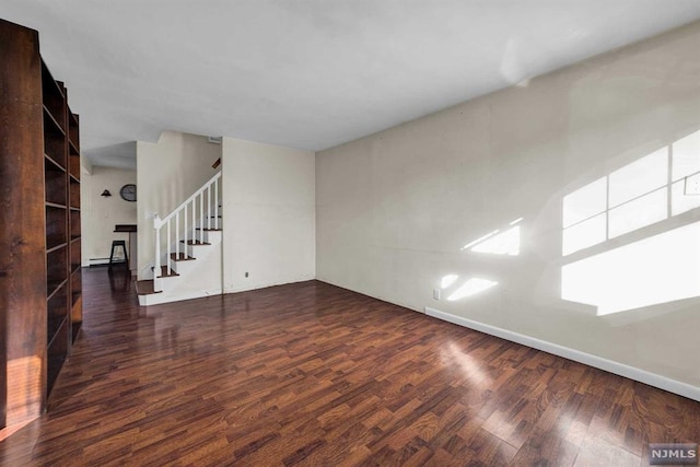 unfurnished living room with dark hardwood / wood-style floors and a baseboard heating unit