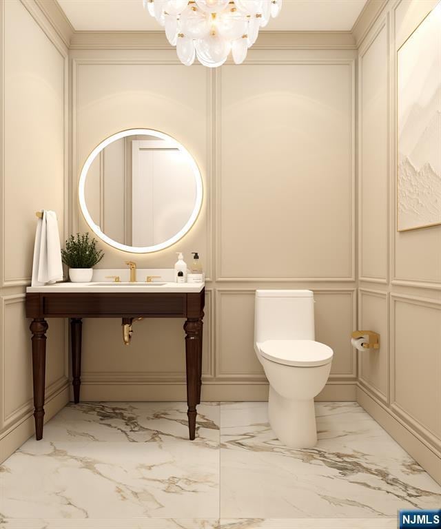 bathroom with a notable chandelier, crown molding, sink, and toilet