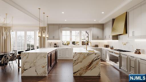 kitchen with light stone countertops, decorative light fixtures, a center island with sink, and wall chimney exhaust hood