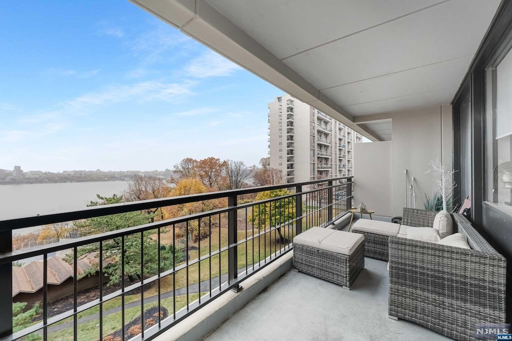 balcony with a water view and an outdoor hangout area