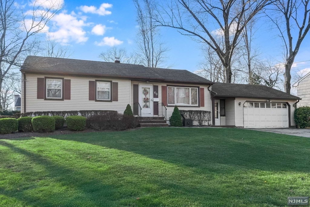 view of front of property featuring a front yard and a garage