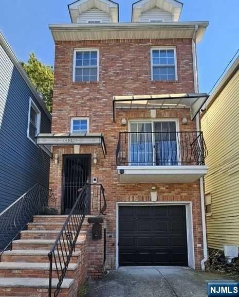 view of front of house with a garage and a balcony