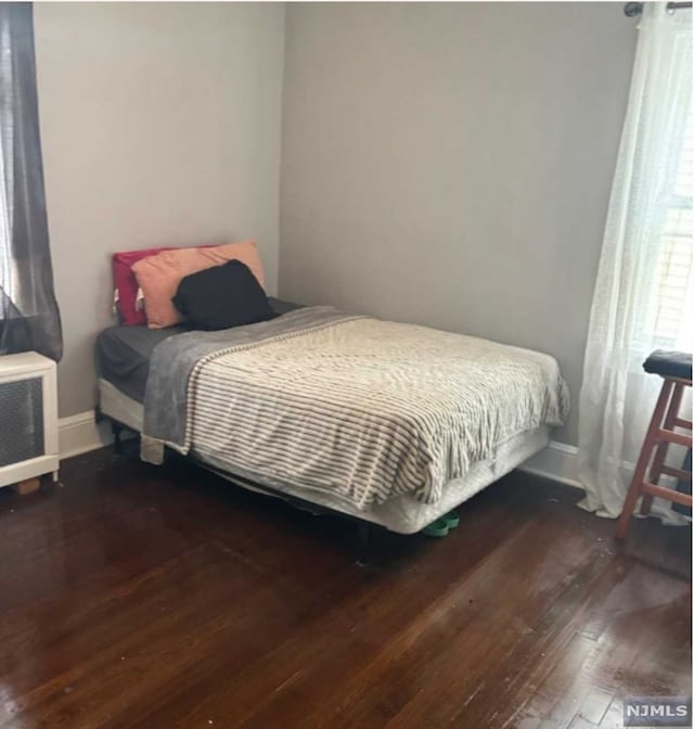 bedroom with dark hardwood / wood-style floors