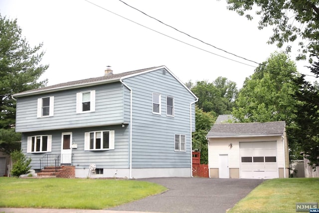 view of front of house featuring a garage, an outdoor structure, and a front lawn