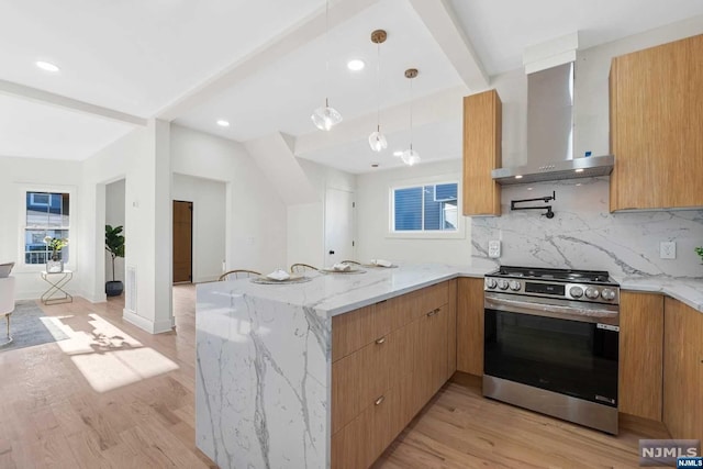 kitchen with stainless steel range, wall chimney exhaust hood, light hardwood / wood-style flooring, beamed ceiling, and kitchen peninsula