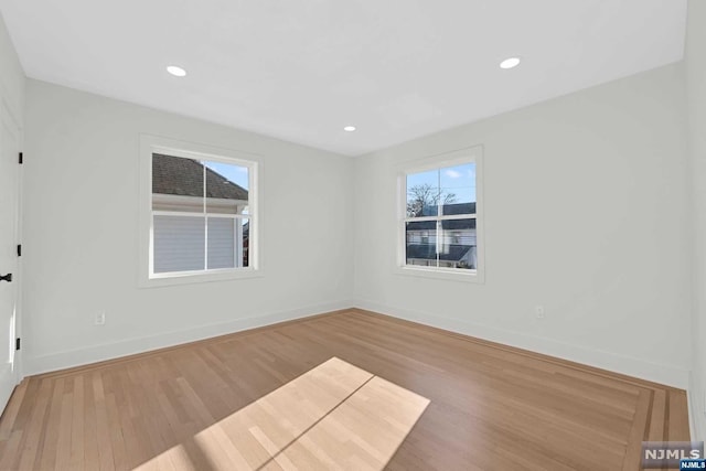 spare room with hardwood / wood-style floors and plenty of natural light