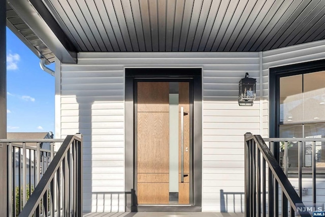 view of exterior entry featuring a balcony