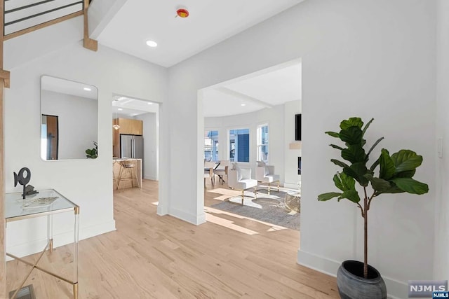 entryway featuring beamed ceiling and light hardwood / wood-style flooring