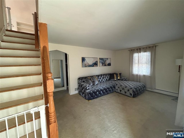 carpeted living room featuring a baseboard heating unit