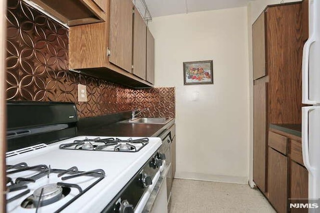 kitchen with white appliances, tasteful backsplash, and sink