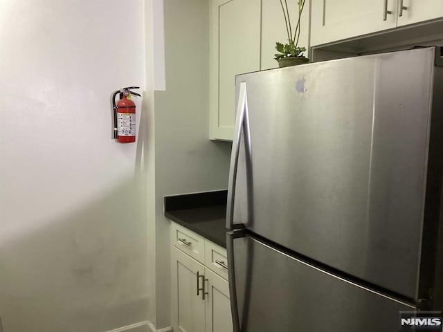 kitchen with white cabinets and stainless steel refrigerator