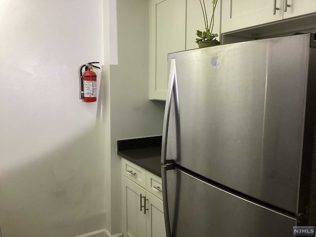 kitchen featuring white cabinets and stainless steel refrigerator