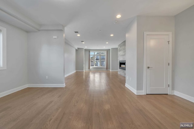 unfurnished living room with a fireplace and light hardwood / wood-style flooring