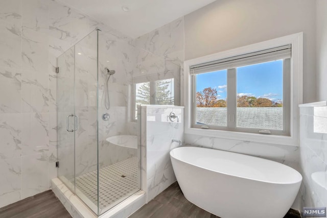 bathroom featuring separate shower and tub, wood-type flooring, and tile walls