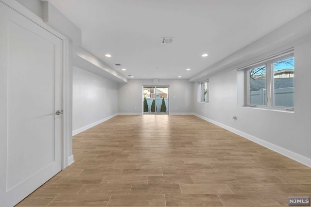 spare room with plenty of natural light and light hardwood / wood-style flooring