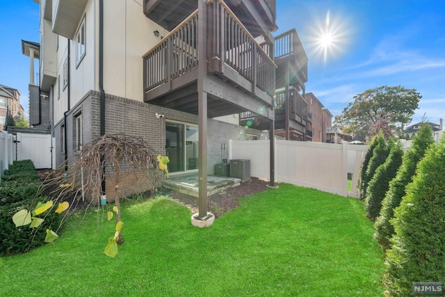 rear view of house featuring a lawn, a balcony, and cooling unit