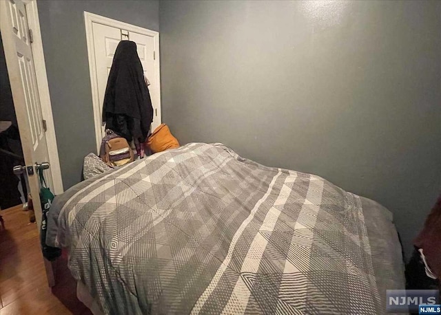 bedroom with a closet and hardwood / wood-style flooring