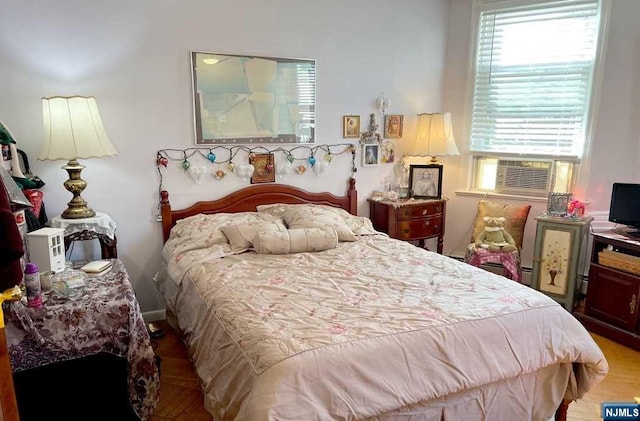 bedroom with cooling unit and wood-type flooring