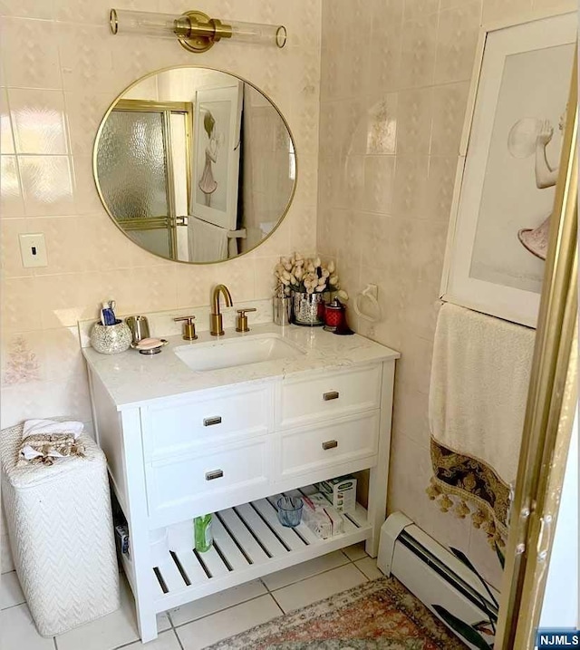 bathroom with a baseboard radiator, tile patterned flooring, backsplash, vanity, and tile walls