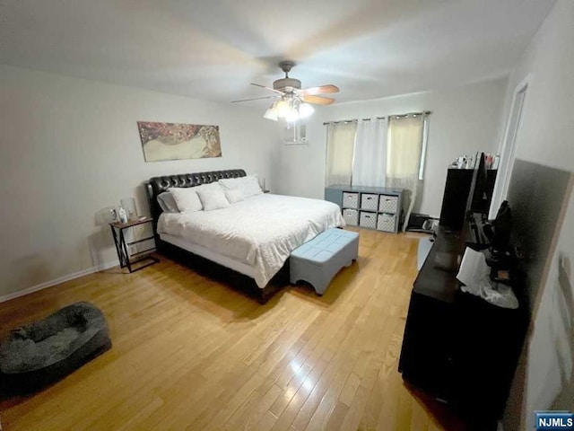 bedroom with ceiling fan and hardwood / wood-style flooring