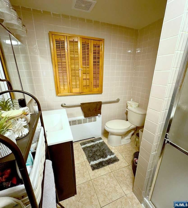 bathroom featuring vanity, tile patterned flooring, toilet, tile walls, and radiator heating unit