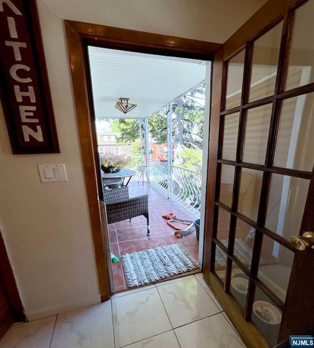 doorway to outside with light tile patterned floors