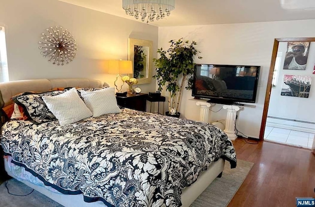 bedroom featuring baseboard heating, hardwood / wood-style floors, a chandelier, and radiator heating unit