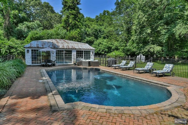 view of pool featuring a patio area and an outbuilding