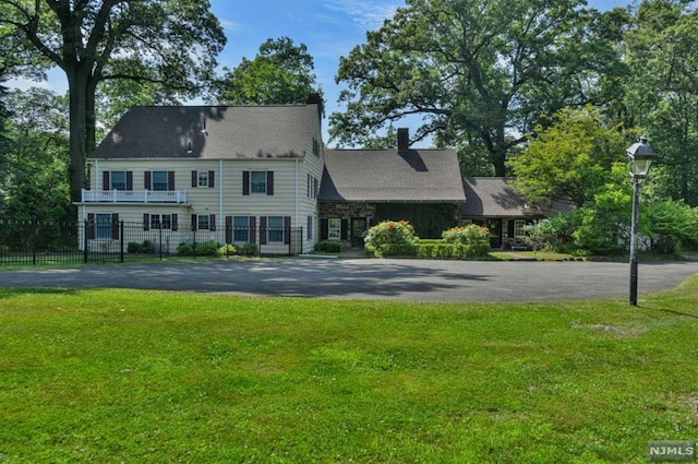 colonial house featuring a front lawn